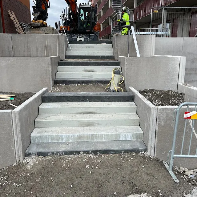 Byggarbetsplats med trappor och grävmaskin