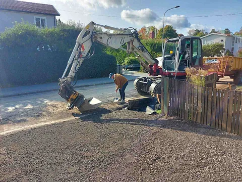 Grävmaskin arbetar på väg